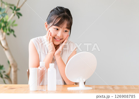 鏡を見ながらニキビケア,スキンケア,メイクする子供,女の子,小学生,中学生 126908785