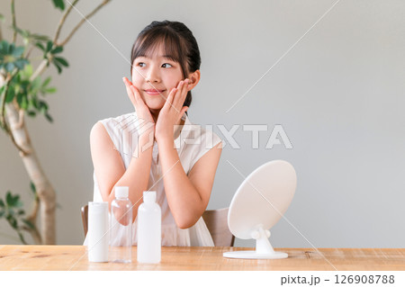 鏡を見ながらニキビケア,スキンケア,メイクする子供,女の子,小学生,中学生 126908788