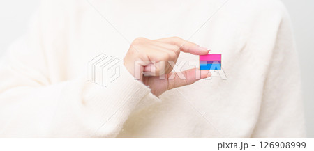 Bisexuality Celebrate Day and LGBT pride month, LGBTQ or LGBTQIA concept. Hand holding purple, pink and blue flag shape for Lesbian, Gay, Bisexual, Transgender, Queer, Pansexual, Marriage Equality Law 126908999