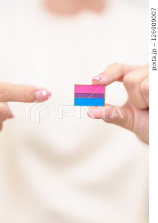 Bisexuality Celebrate Day and LGBT pride month, LGBTQ or LGBTQIA concept. Hand holding purple, pink and blue flag shape for Lesbian, Gay, Bisexual, Transgender, Queer, Pansexual, Marriage Equality Law 126909007