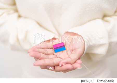 Bisexuality Celebrate Day and LGBT pride month, LGBTQ or LGBTQIA concept. Hand holding purple, pink and blue flag shape for Lesbian, Gay, Bisexual, Transgender, Queer, Pansexual, Marriage Equality Law Bisexuality Celebrate Day and LGBT pride month, LGBTQ or LGBTQIA concept. Hand holding purple, pink and blue flag shape for Lesbian, Gay, Bisexual, Transgender, Queer, Pansexual, Marriage Equality Law 126909008