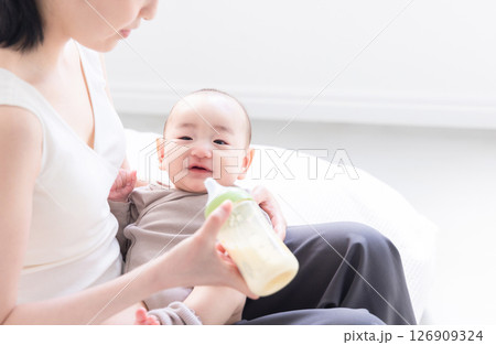 赤ちゃんにミルクを飲ませる若いお母さん 126909324
