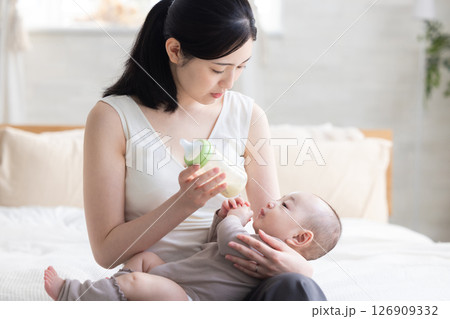 赤ちゃんにミルクをあげる母親 赤ちゃんにミルクをあげる母親 126909332