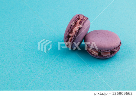 Delicious purple macarons on a vibrant blue background Delicious purple macarons on a vibrant blue background 126909662