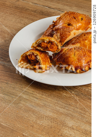 Homemade pumpkin pastries on a white plate with wooden background Homemade pumpkin pastries on a white plate with wooden background 126909728