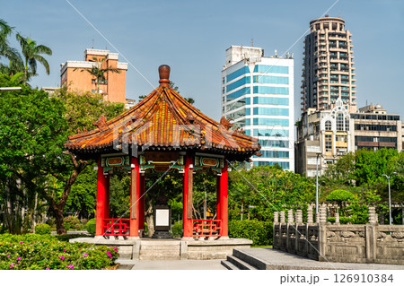 A traditional Chinese pavilion in 228 Peace Memorial Park, Taipei, Taiwan, stands elegantly before a backdrop of modern skyscrapers, reflecting the contrast between cultural heritage and urban 126910384