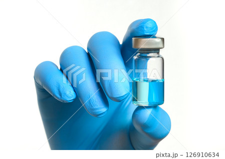 doctor's hand holds a syringe and a blue vaccine bottle at the hospital. Health and medical concepts. 126910634