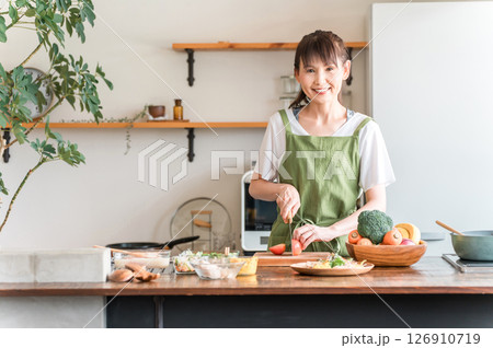 キッチンで料理をする中高年のアジア人女性(切る・包丁・クッキング・手料理) キッチンで料理をする中高年のアジア人女性(切る・包丁・クッキング・手料理) 126910719