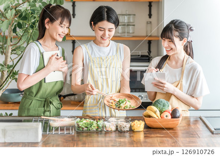 料理教室・クッキングスクールで料理を教える講師の女性と生徒の女性 料理教室・クッキングスクールで料理を教える講師の女性と生徒の女性 126910726