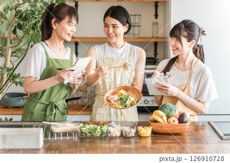 料理教室・クッキングスクールで料理を教える講師の女性と生徒の女性 料理教室・クッキングスクールで料理を教える講師の女性と生徒の女性 126910728