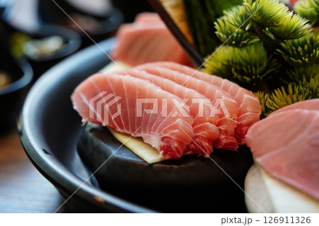 Close-up of Sliced Tuna Sashimi on Black Plate 126911326
