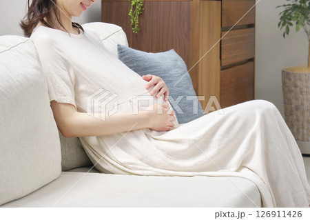ソファーに座ってお腹を触る妊婦 顔無し ソファーに座ってお腹を触る妊婦 顔無し 126911426