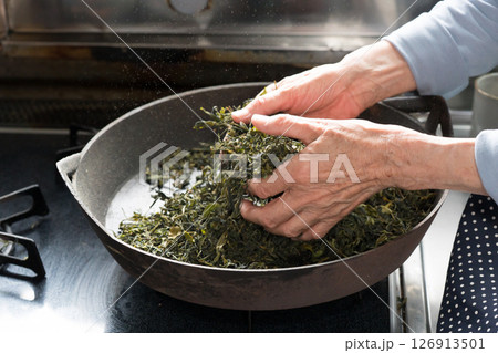 炮烙鍋でお茶の葉を乾燥しているシニア女性 炮烙鍋でお茶の葉を乾燥しているシニア女性 126913501