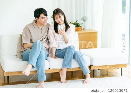 リビングでスマホを見るカップル 126913971