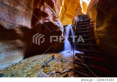 Waterfall Motion Beside Metal Staircase in Red Slot Canyon Low Perspective 126914383