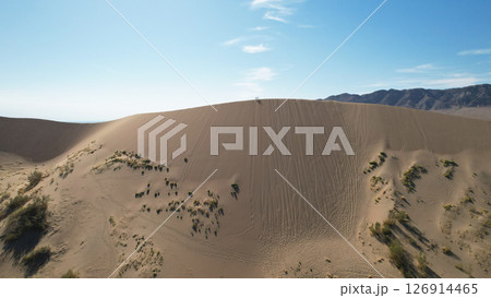 Hikers walking on the crest of a sand dune in the desert Hikers walking on the crest of a sand dune in the desert 126914465