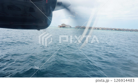 Seaplane flying over water bungalows in the maldives Seaplane flying over water bungalows in the maldives 126914483