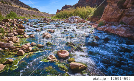 Aerial Motion Over Virgin River Flowing Through Rugged Desert Canyon 126914693