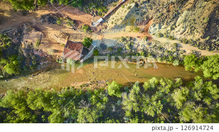 Aerial Top Down Red Roofed Building and Winding River in Rocky Green Landscape 126914724