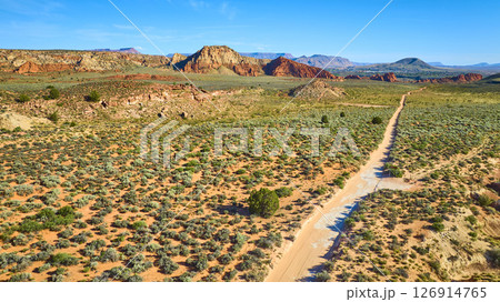 Aerial Fly Over Desert Road and Red Rock Mesas with Sagebrush Patterns Aerial Fly Over Desert Road and Red Rock Mesas with Sagebrush Patterns 126914765