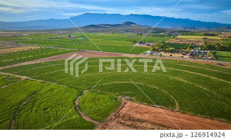 Aerial Pivot Irrigation Circle and Farmland with Mountain Backdrop Fly Over Aerial Pivot Irrigation Circle and Farmland with Mountain Backdrop Fly Over 126914924