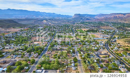 Aerial Small Town Neighborhoods with Red Rock Mountains and Green Trees Fly Over 126914958