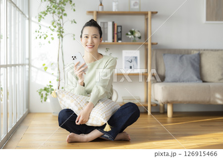リビングでスマホを見ている女性 126915466