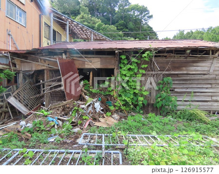 放置されて倒壊した木製の廃屋 126915577