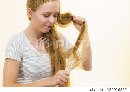 Blonde girl brushing her long hair Blonde girl brushing her long hair 126916825