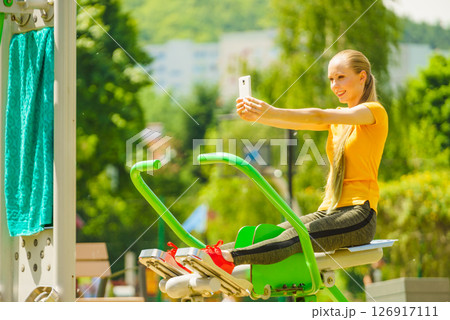 Girl doing exercises outdoor, taking selfie 126917111