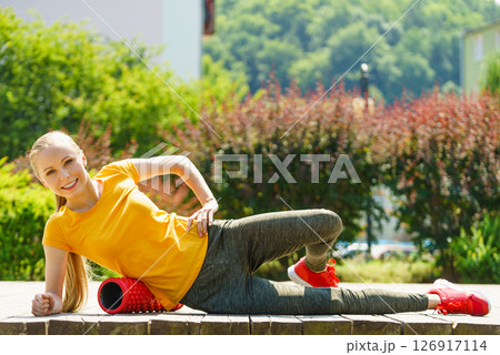 Girl doing exercises outdoor, using roller Girl doing exercises outdoor, using roller 126917114