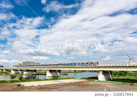 小田急小田原線と多摩川の景色　鉄橋を走る電車　登戸駅直近　春の青空　神奈川県川崎市多摩区登戸新町 126917841