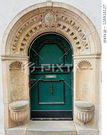 Ancient stone arch with wooden entrance door. Architecture of Europe. 126918127