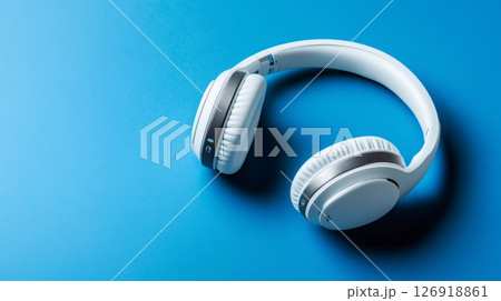 White Wireless Headphones Lying on Vibrant Blue Background 126918861