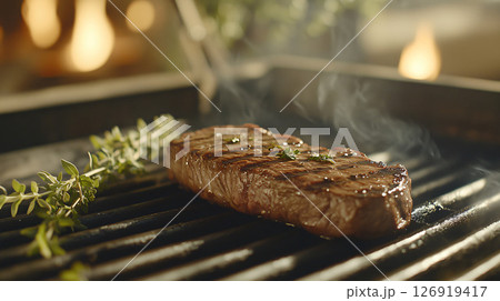 Juicy grilled steak with thyme grilling on hot barbecue grill 126919417