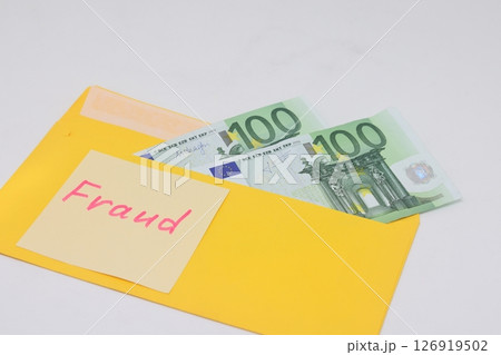 Banknotes in a yellow envelope. Fraud concept. Financial fraud. Close-up. Sticker labeled scam. 126919502