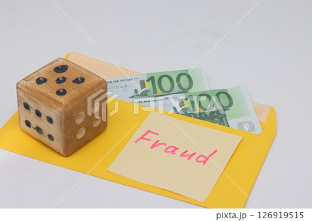 Banknotes in a yellow envelope. Fraud concept. Financial fraud. Dice. Sticker labeled scam, fraudm. 126919515