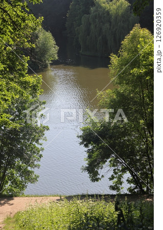 Beautiful colorful summer spring natural landscape with a lake in Park surrounded by green foliage Beautiful colorful summer spring natural landscape with a lake in Park surrounded by green foliage 126920359