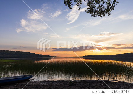 A tranquil lake view during sunset featuring peaceful reflections 126920748