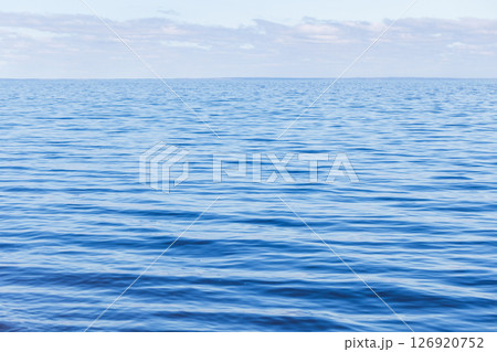 A serene sea view under a clear sky, highlighting the calm and tranquility A serene sea view under a clear sky, highlighting the calm and tranquility 126920752