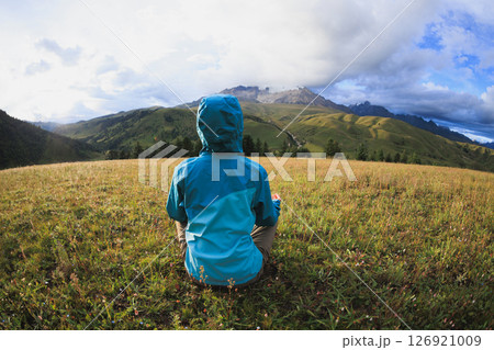 Woman hiker meditation on the high altitude mountain top grassland Woman hiker meditation on the high altitude mountain top grassland 126921009