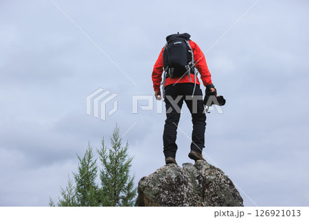 Successful hiker with camera on mountain top 126921013
