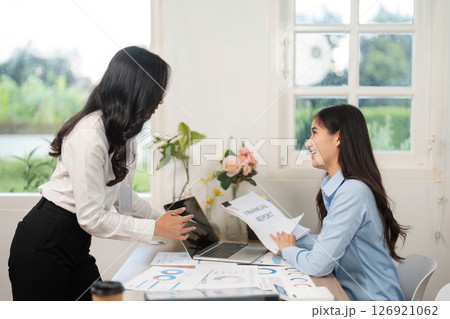 Positive Workplace Collaboration. Two women sharing ideas while working on a laptop. 126921062