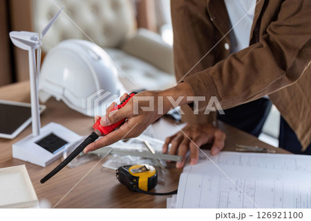 ESG Principles in Action. Architect measuring dimensions for a sustainable project. 126921100