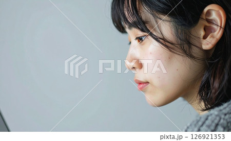 横顔でPC作業に集中する若い女性 126921353