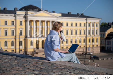 woman with a laptop and a bottle of water sits on the steps of the Senate Square in Helsinki woman with a laptop and a bottle of water sits on the steps of the Senate Square in Helsinki 126922612