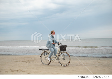 Woman riding bicycle on North sea coast in Denmark 126922687