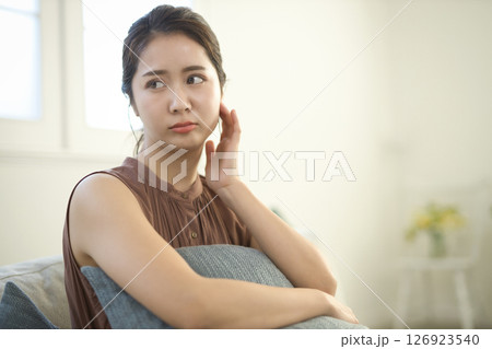 ソファに座る体調不良の20代女性 126923540