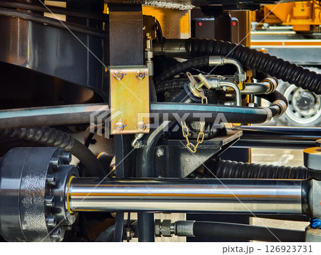 Close-up view of hydraulic system components on construction machinery at a work site 126923731