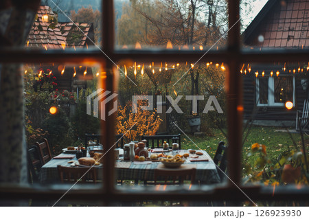 Scenic view of a festive dinner gathering in a backyard surrounded by nature 126923930
